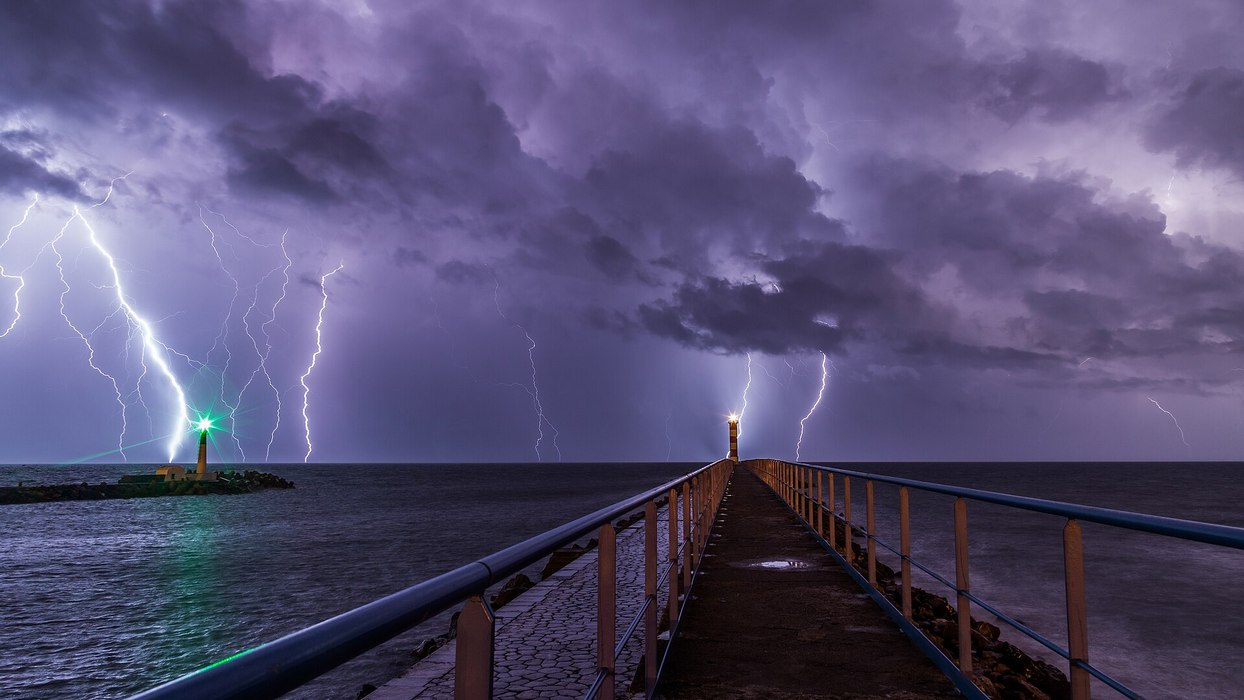 Port and lighthouse overnight storm with lightning in Port la Nouvelle